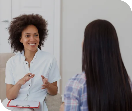woman therapist holding pencil and notepad talking to client